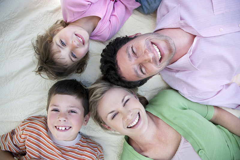 幸福的一家人躺在毯子上的合影图片下载