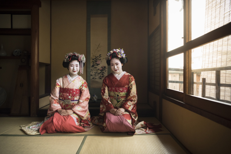 两个日本舞妓穿着和服跪在地板上图片下载