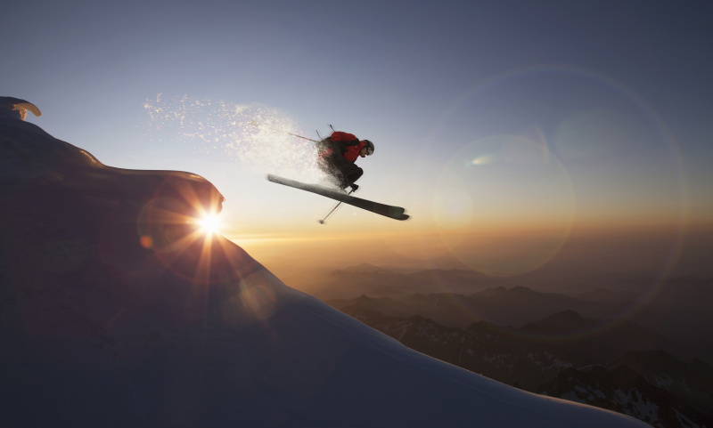 瑞士华利斯州采尔马特，日落时分，滑雪者在雪坡上跳跃图片下载