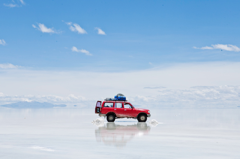 在潮湿的沙子上穿越玻利维亚的汽车风景图片素材