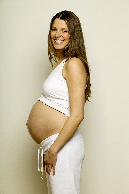 孕妇微笑，侧视图图片下载