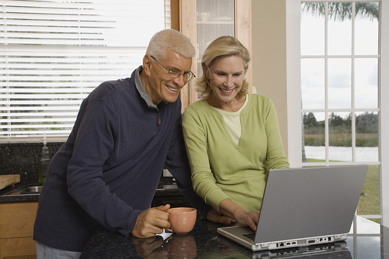 一对老年夫妇在用笔记本电脑图片下载
