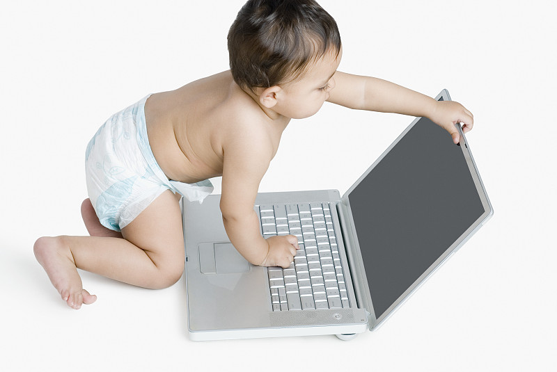 一个小女孩在玩笔记本电脑的高角度视图图片下载