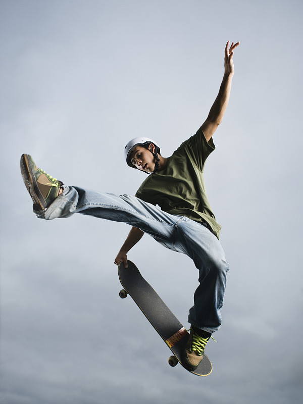混血少年在半空中玩滑板图片下载