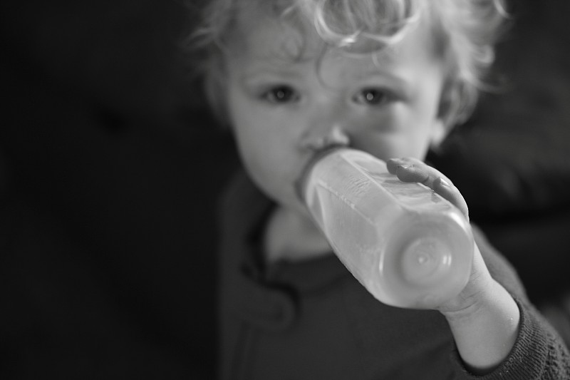 蹒跚学步的男孩喝牛奶图片下载