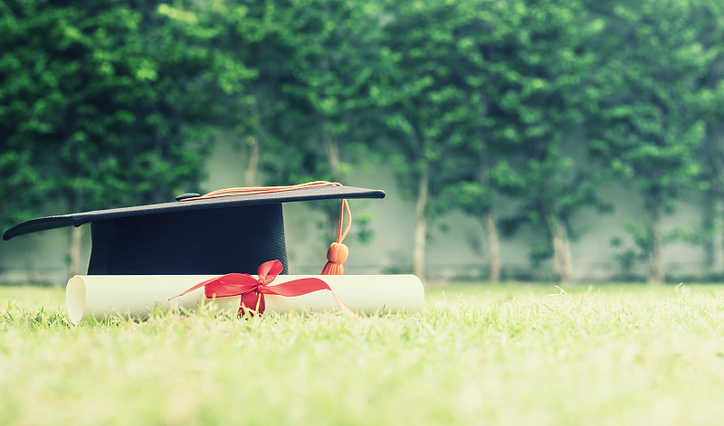 学位帽和草地上的证书图片素材