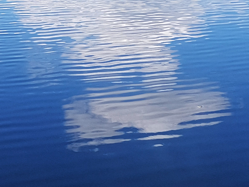 大云的倒影在涟漪的水面上的池塘，完整的框架图片下载