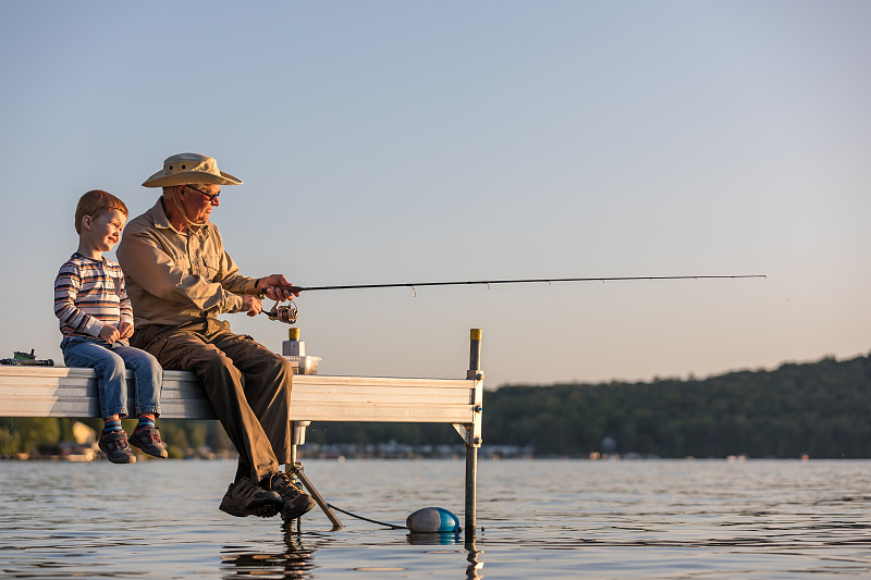 爷爷和孙子在夏天的日落钓鱼图片下载
