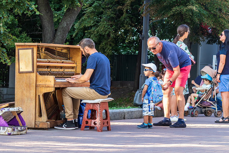 不明身份的音乐家在基辅中心的米哈伊洛夫斯卡娅广场上弹奏钢琴。街头文化。图片下载