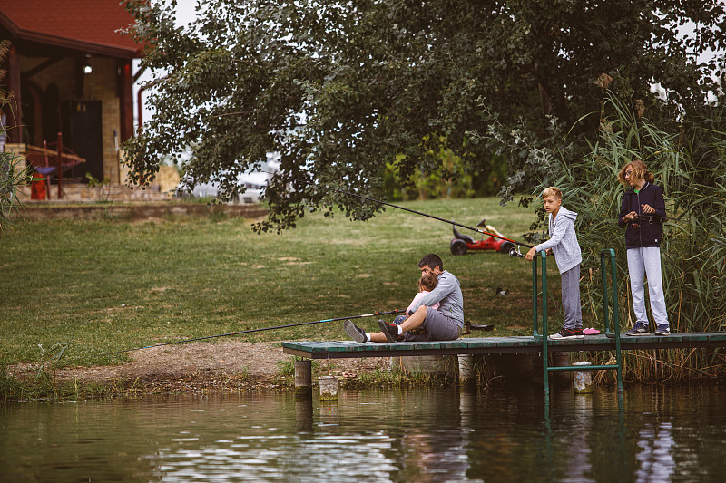 家人在河边享受一段和平时光的正面视图图片素材