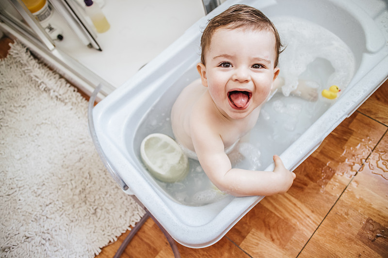 浴缸里的男婴伸出舌头的肖像图片下载