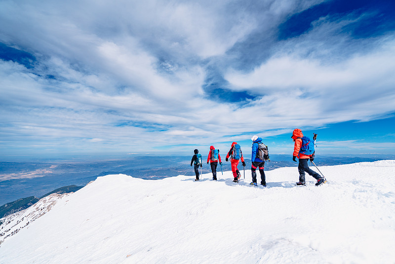冬季，高山登山队一行走到高海拔的山峰图片下载