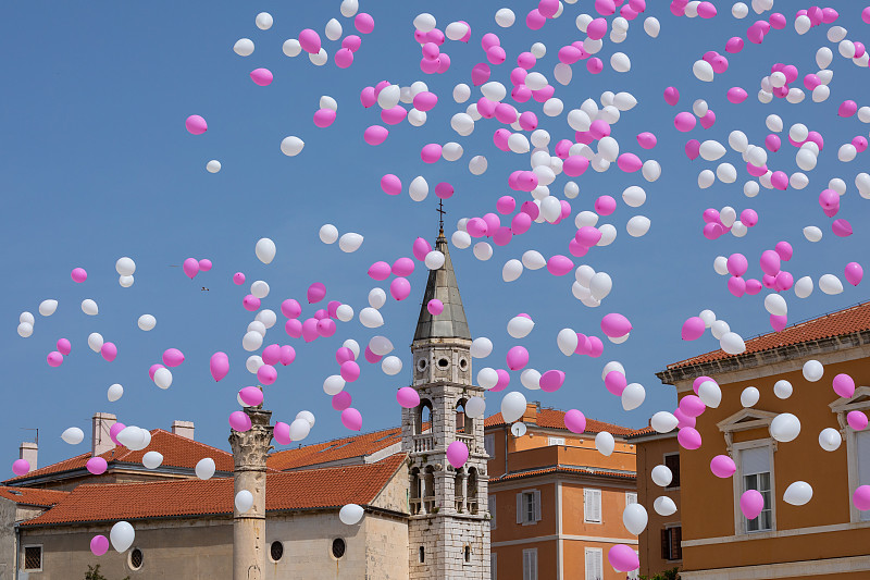 位于欧洲地中海的克罗地亚小镇扎达尔的历史中心，蓝色的天空上飘着粉色和白色的气球。图片下载