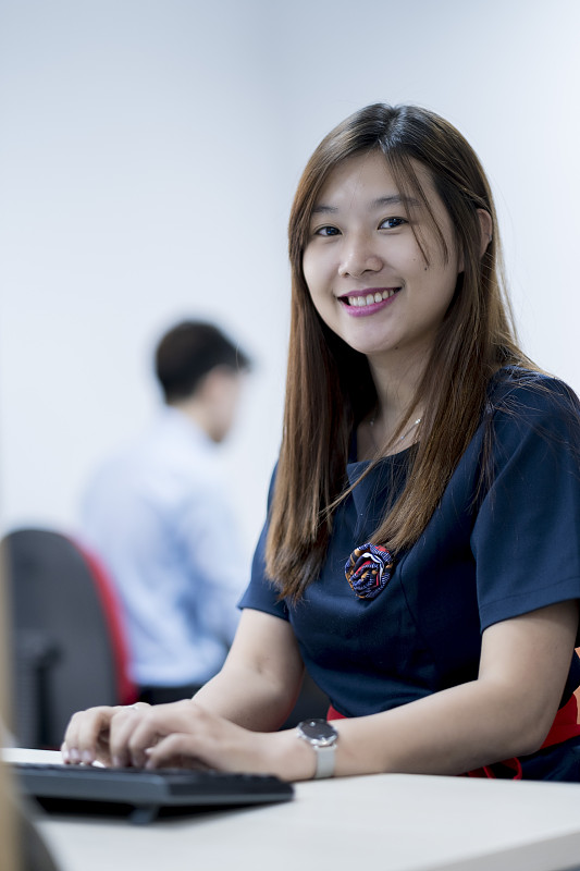 一位亚洲白领坐在她的办公桌前图片下载