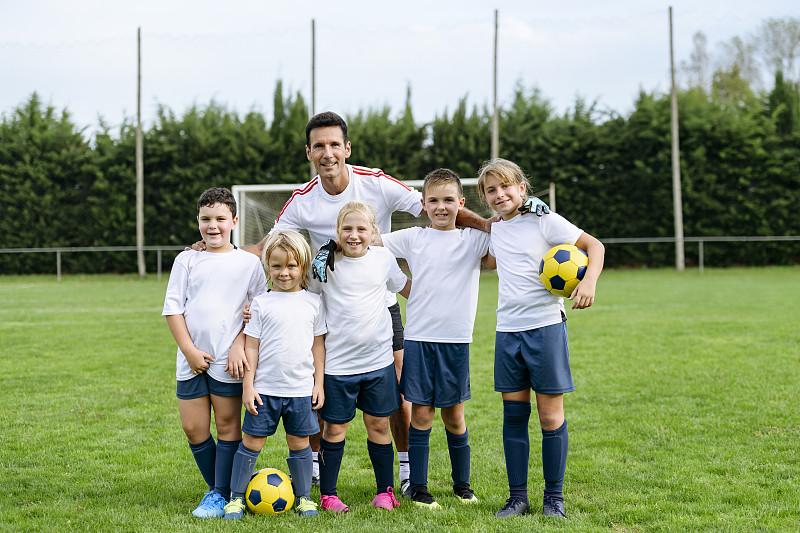 年轻的男孩和女孩足球运动员和教练的集体肖像图片下载