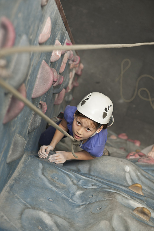 在英国，一个小女孩在爬室内攀岩墙图片下载