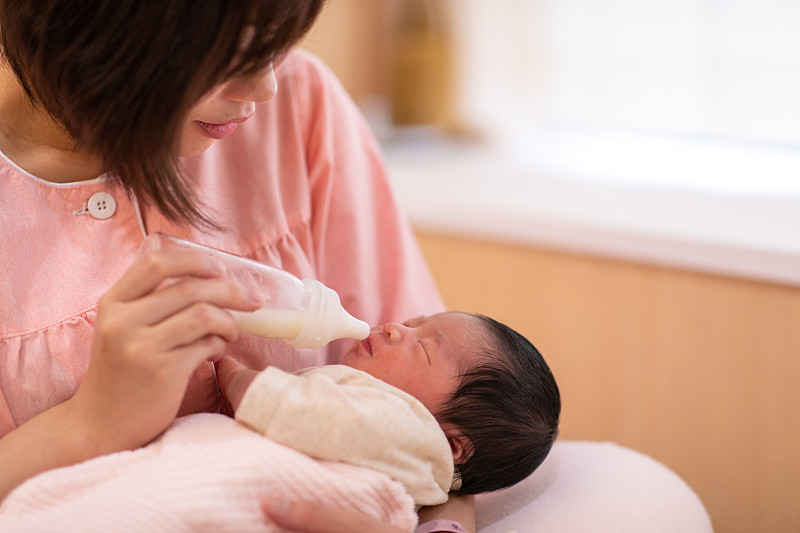 年轻的母亲在医院给新生婴儿喂奶图片素材