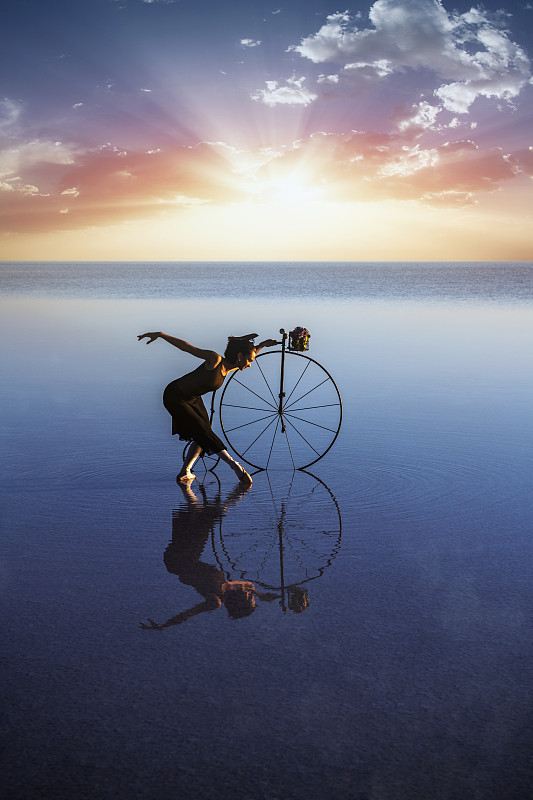 芭蕾舞演员在湖上骑着旧自行车跳舞图片素材