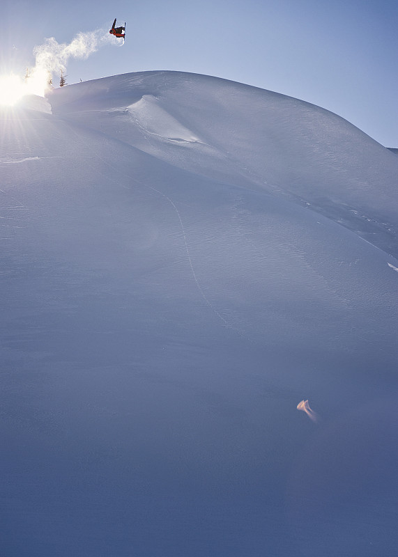 远处滑雪板在半空中跃过山坡、高山图片素材