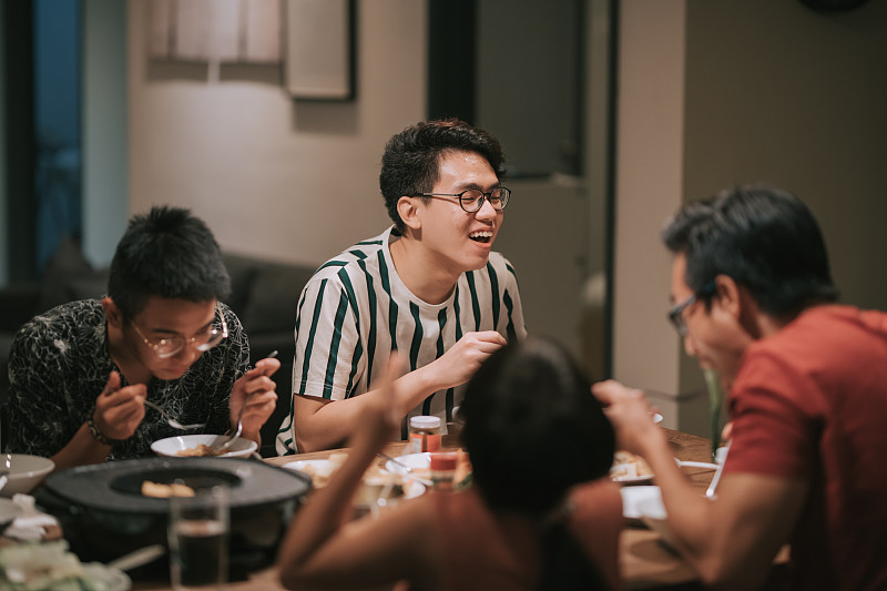 一个亚洲华人家庭和朋友在家里吃着传统的中国汽船菜共进晚餐图片素材