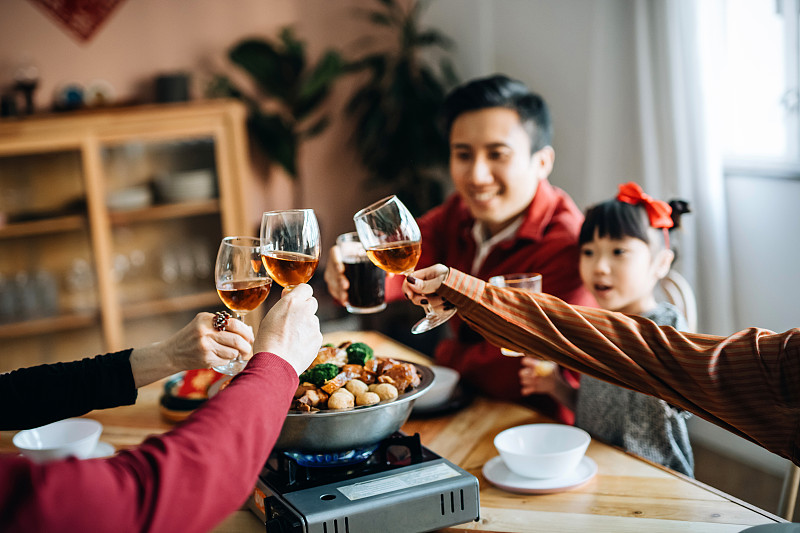 三代快乐的亚洲家庭庆祝中国新年，一边品尝美味的传统中国菜，一边品尝团圆饭图片下载