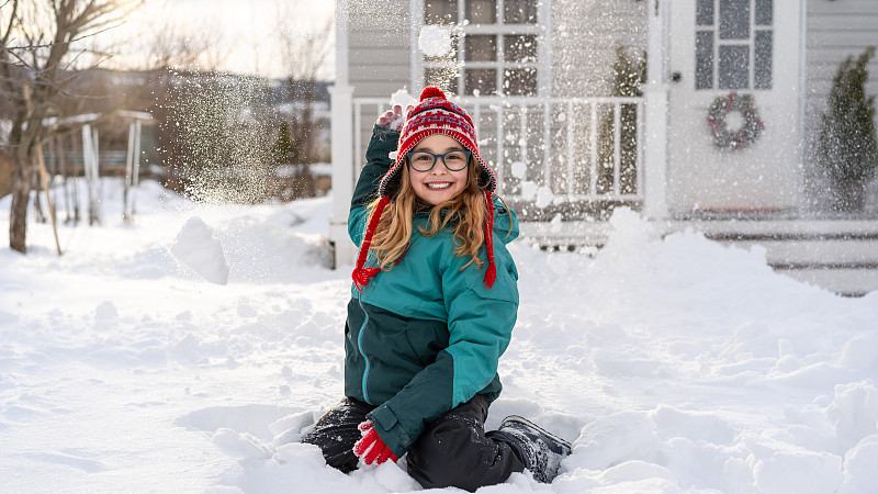 女孩在美国房子前玩雪图片素材