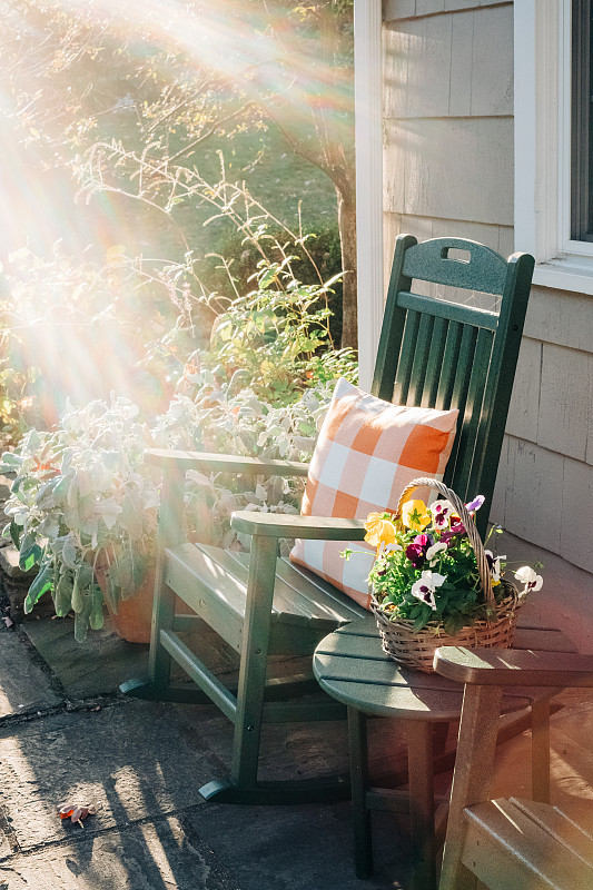 阳光普照的露台上的绿色摇椅图片素材