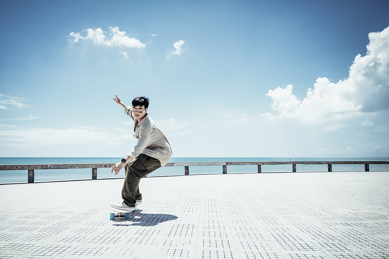 亚洲男子在美丽的夏日户外滑板图片下载