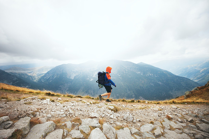 独自背着背包在山脊上徒步旅行的男人图片下载