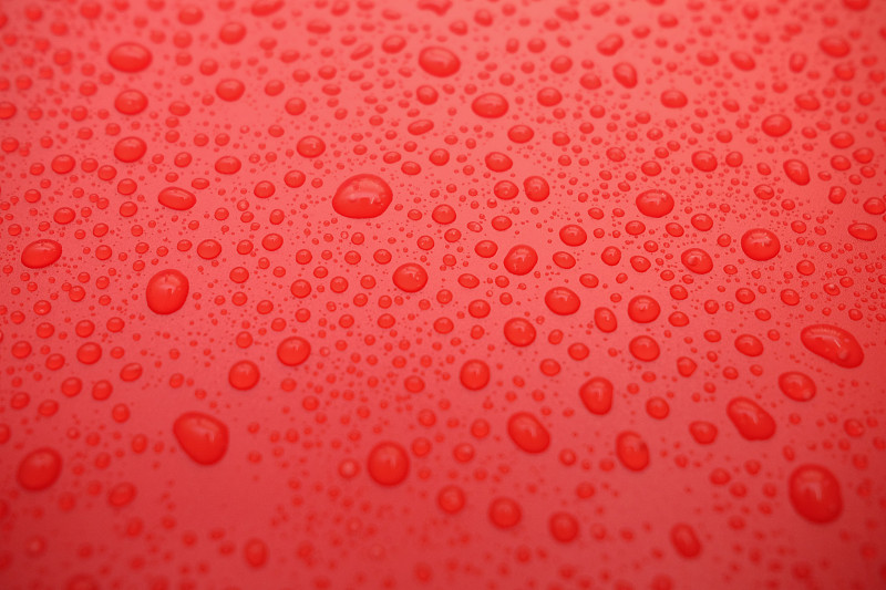 彩色背景上的水滴。红色调。摄影图片
