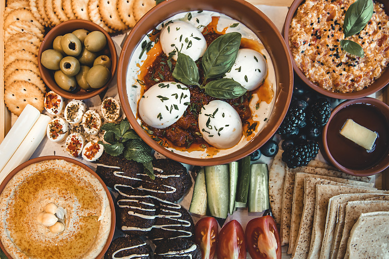 平铺:传统的阿拉伯早餐，鸡蛋，橄榄，鹰嘴豆泥，皮塔饼，蔬菜，沙拉三明治，蜂蜜，菲达奶酪。图片下载
