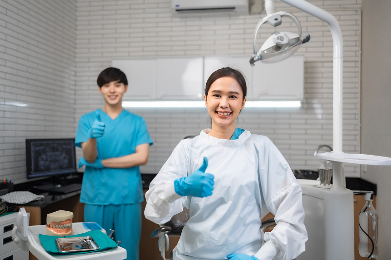 年轻的亚洲女牙医在牙科诊所看着相机。白诊所女医生的特写照片。摄影图片下载