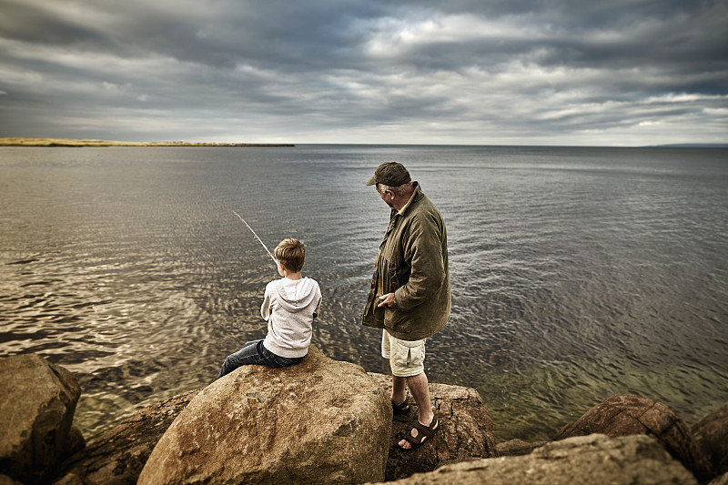英国，苏格兰，男孩和老人一起钓鱼图片下载