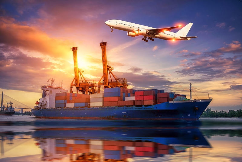 物流与运输的集装箱货轮和货机与工作起重机桥在日出船厂，物流进出口和运输行业背景图片下载