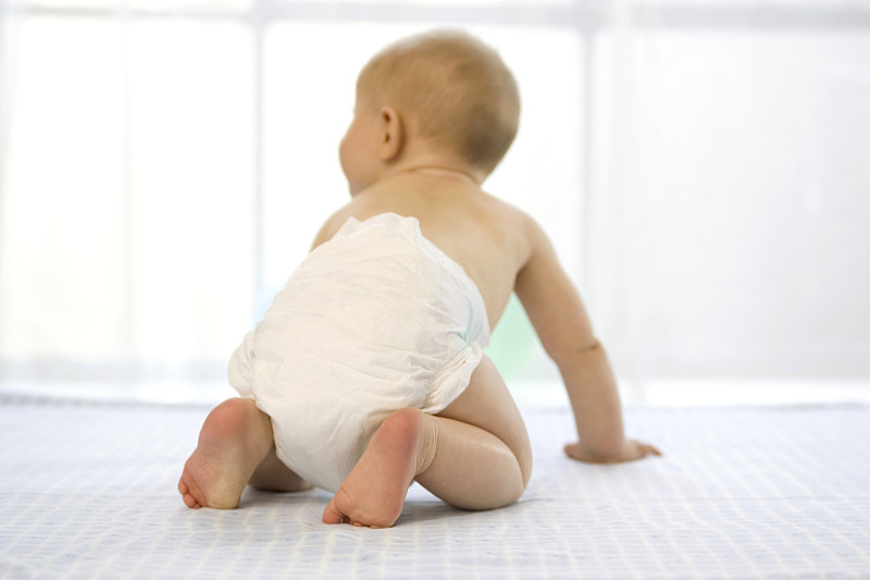 Baby boy (6-12 months) crawling,rear view图片素材
