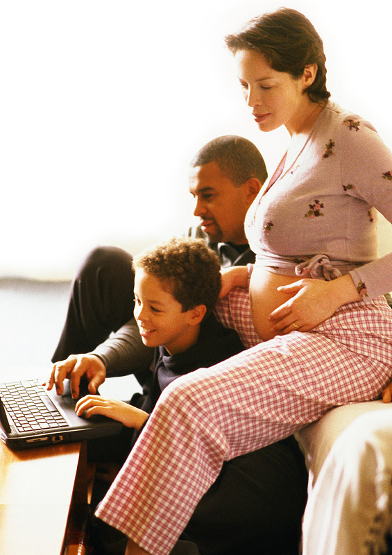 孕妇坐在男人旁边，孩子坐在电脑前图片下载