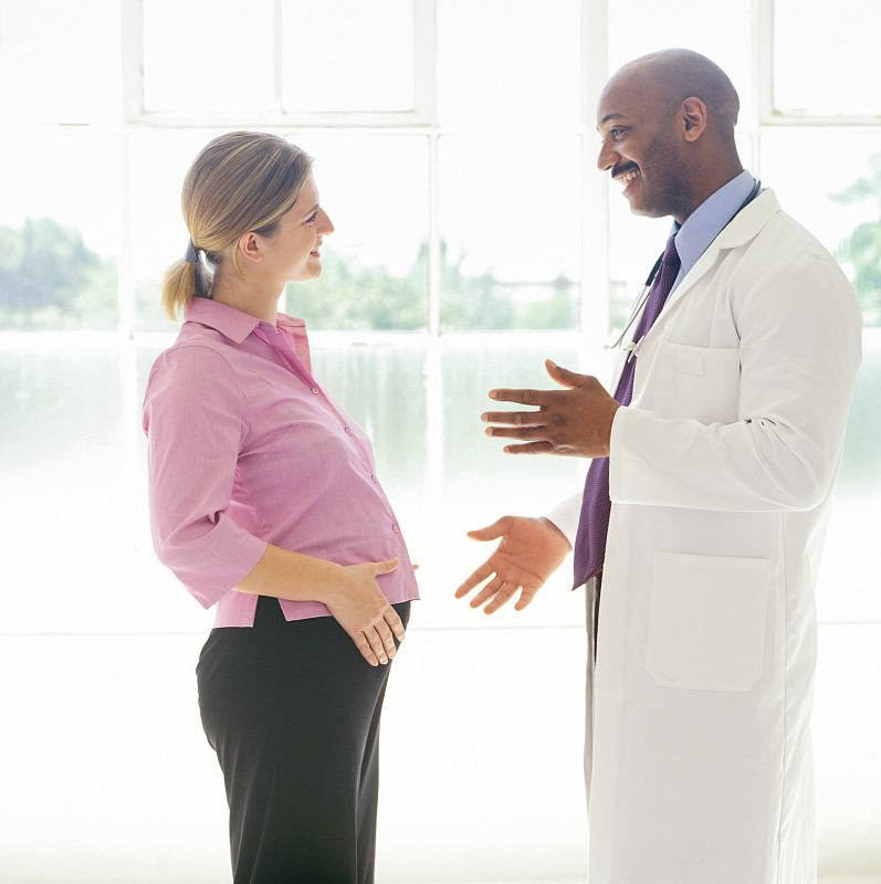 一个年轻孕妇和医生谈话的肖像图片下载