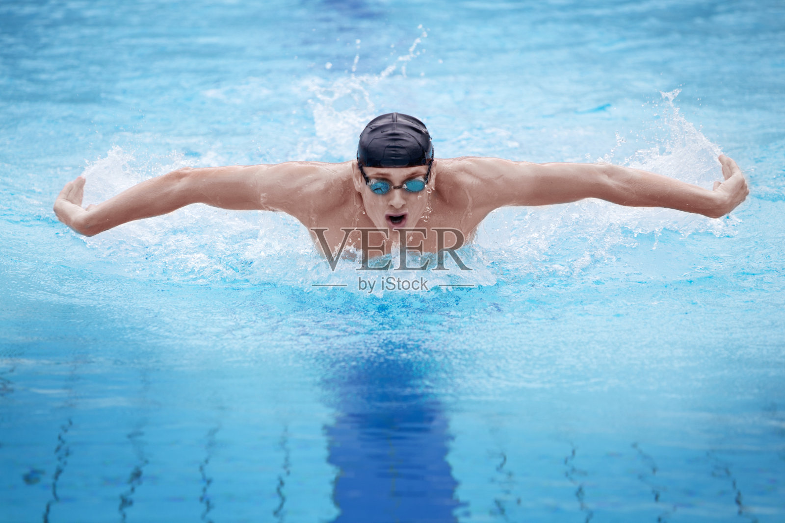 一个游泳运动员表演蝶泳的照片照片摄影图片