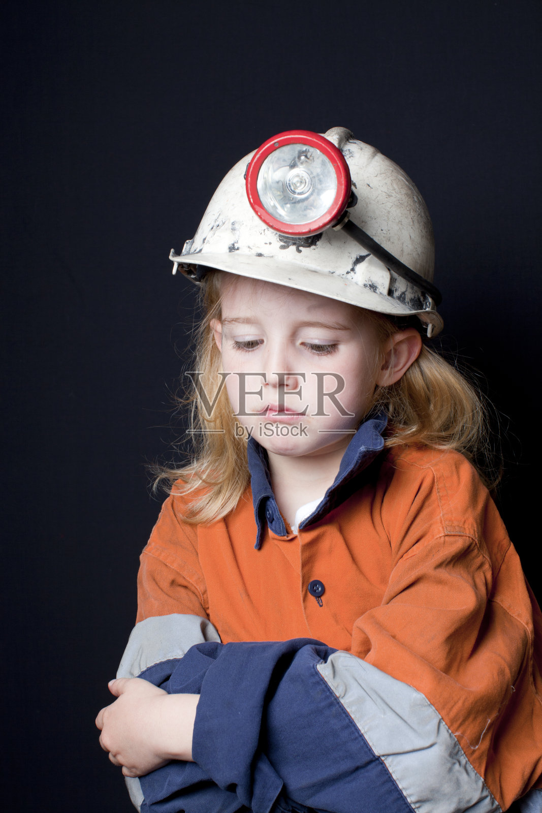 年轻的女孩戴着矿工安全帽和安全服照片摄影图片