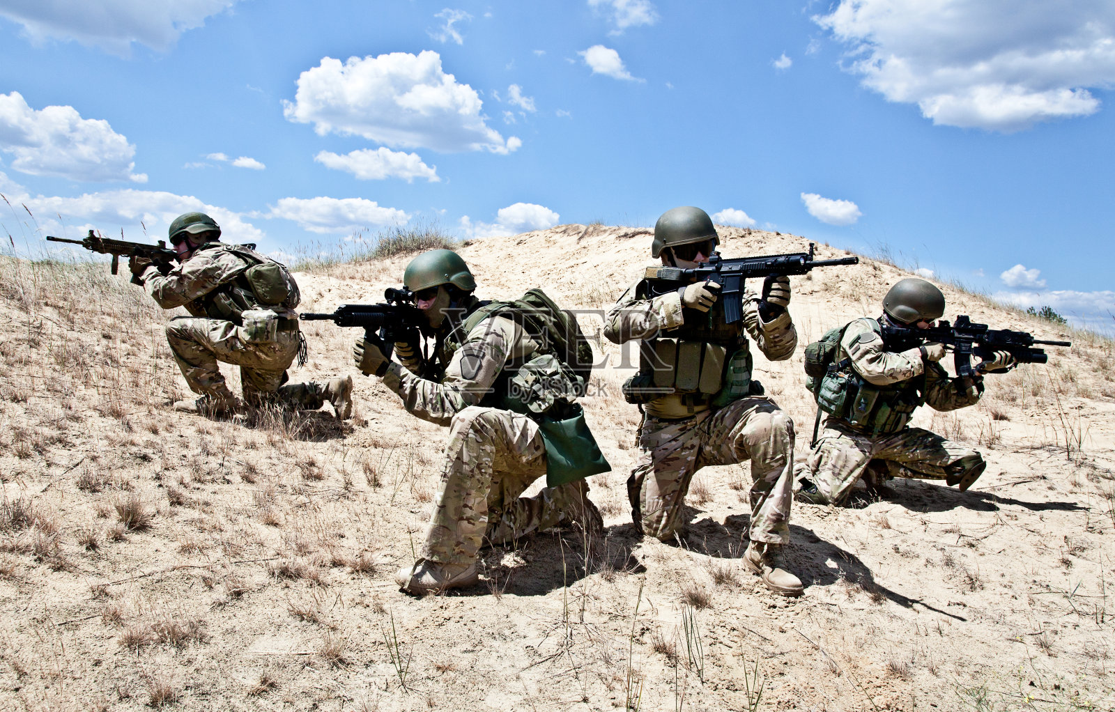 沙漠中四名身穿战术装备的军人组成的小组照片摄影图片
