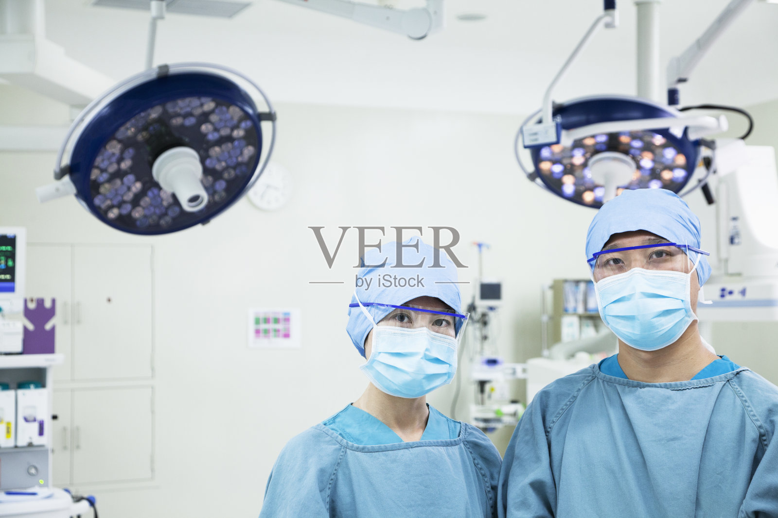 两名外科医生戴着口罩在手术室里照片摄影图片