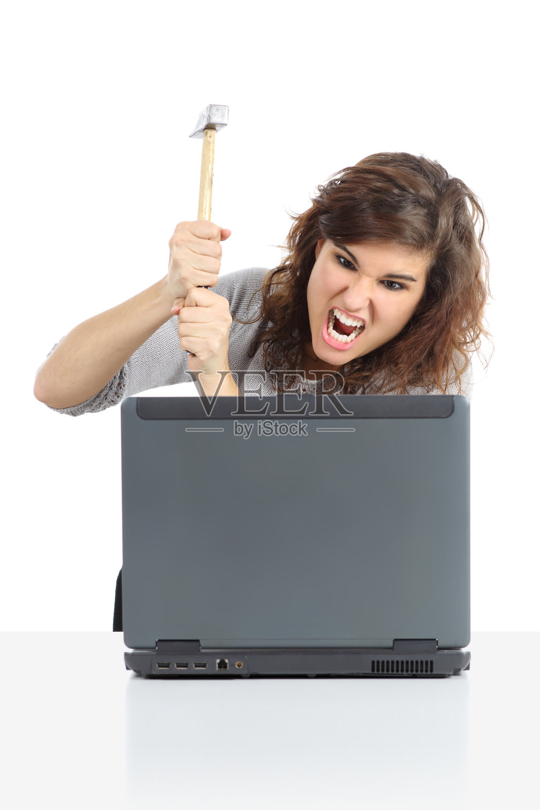愤怒的女人用锤子砸电脑照片摄影图片