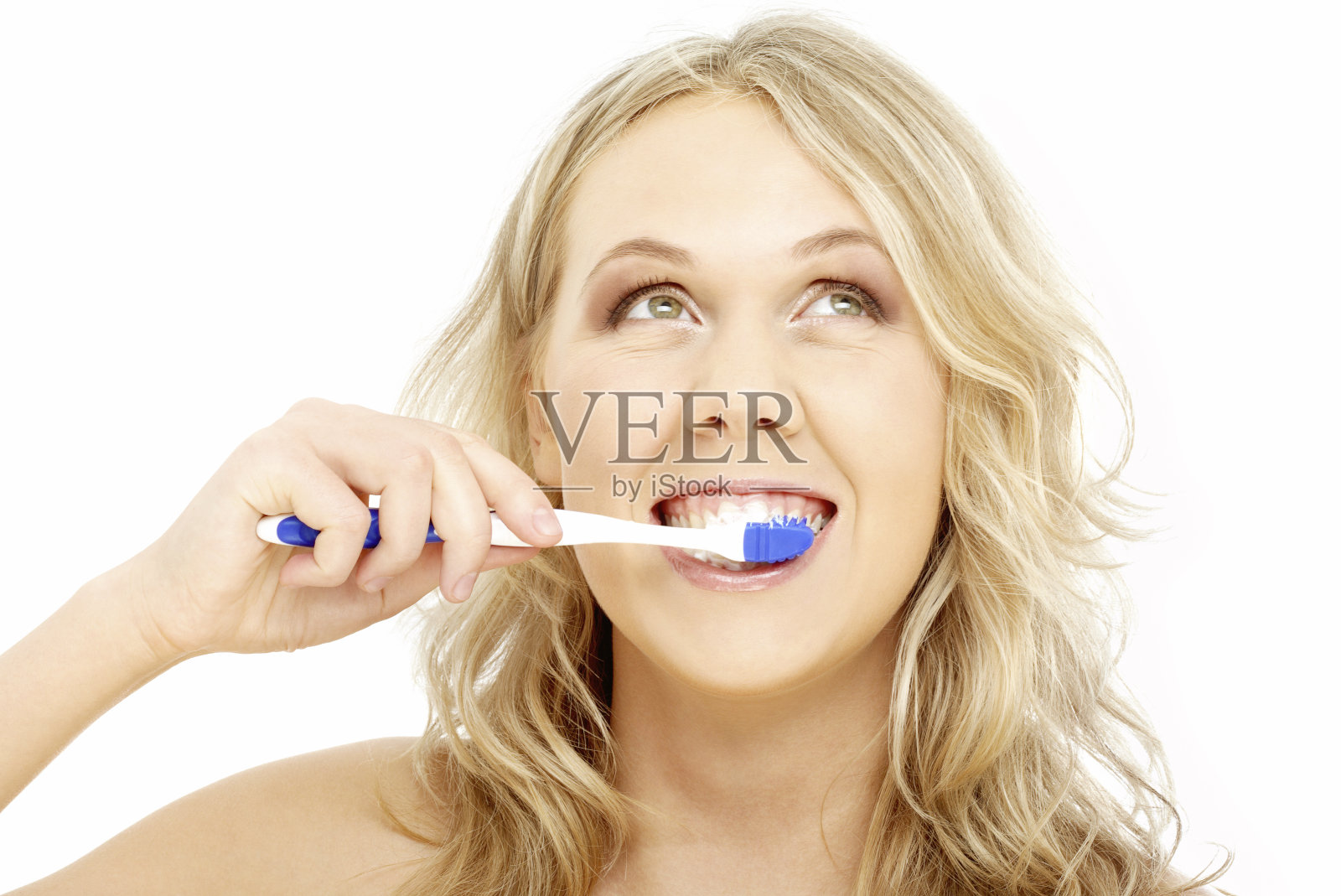 金发的人用蓝白相间的牙刷刷牙照片摄影图片
