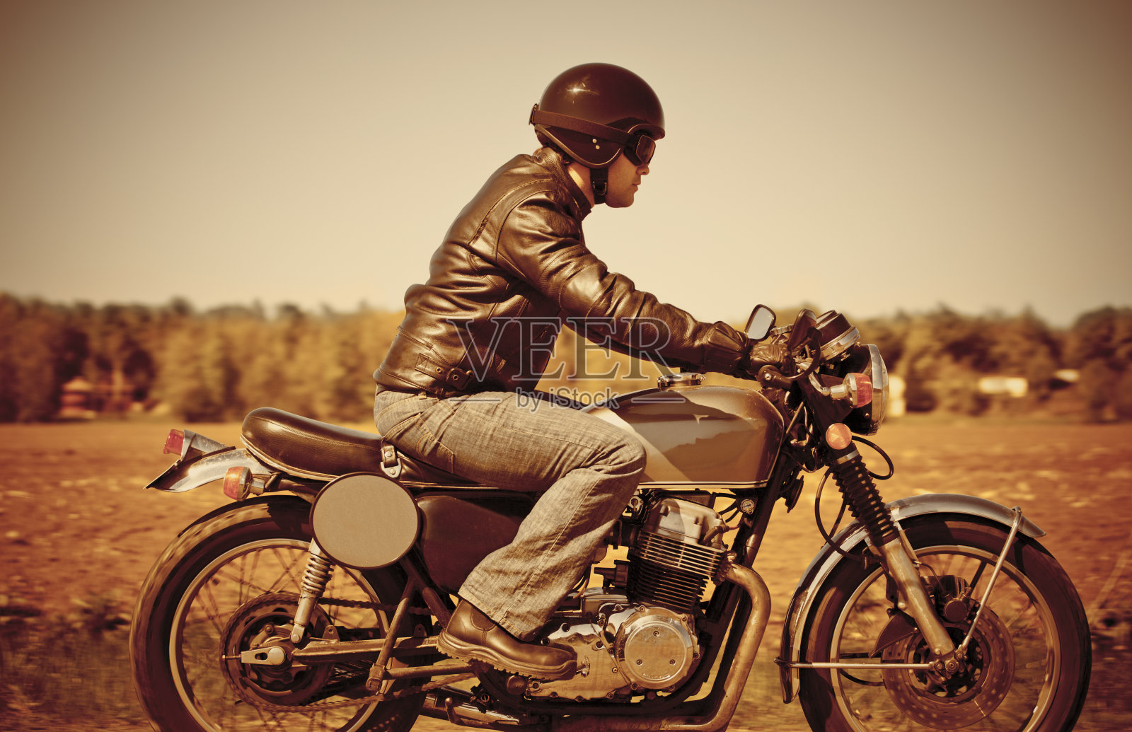 穿着皮夹克，骑着老式摩托车的男人照片摄影图片