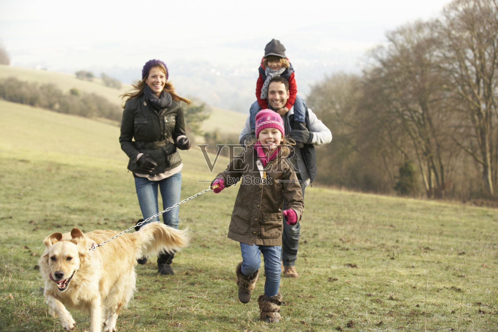 冬天，家人和狗在乡村散步照片摄影图片
