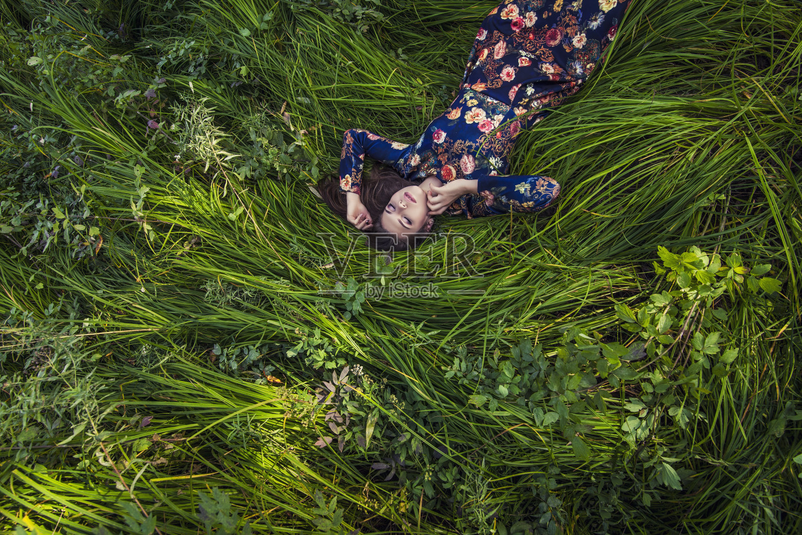 美丽的年轻女子穿着衣服躺在草地上照片摄影图片