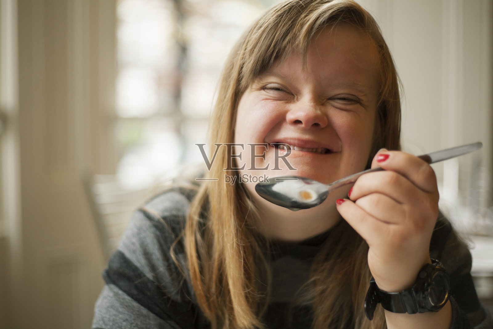 年轻女子面带微笑，举着勺子照片摄影图片