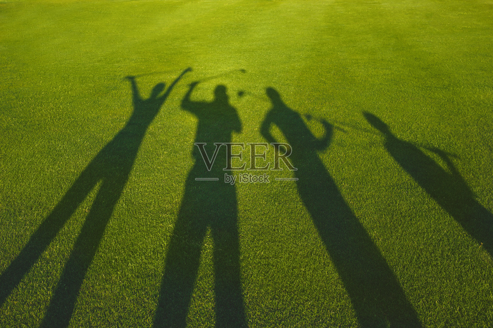 四名高尔夫球手在草地上剪影照片摄影图片