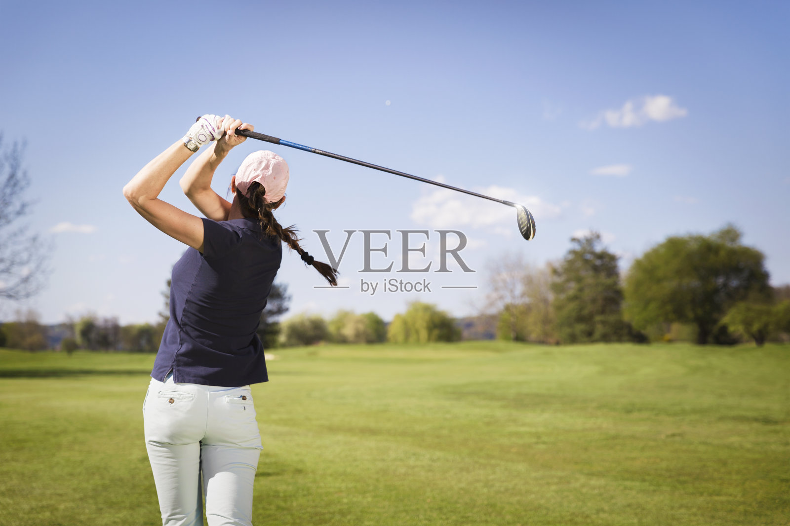 女子高尔夫球运动员开球。照片摄影图片