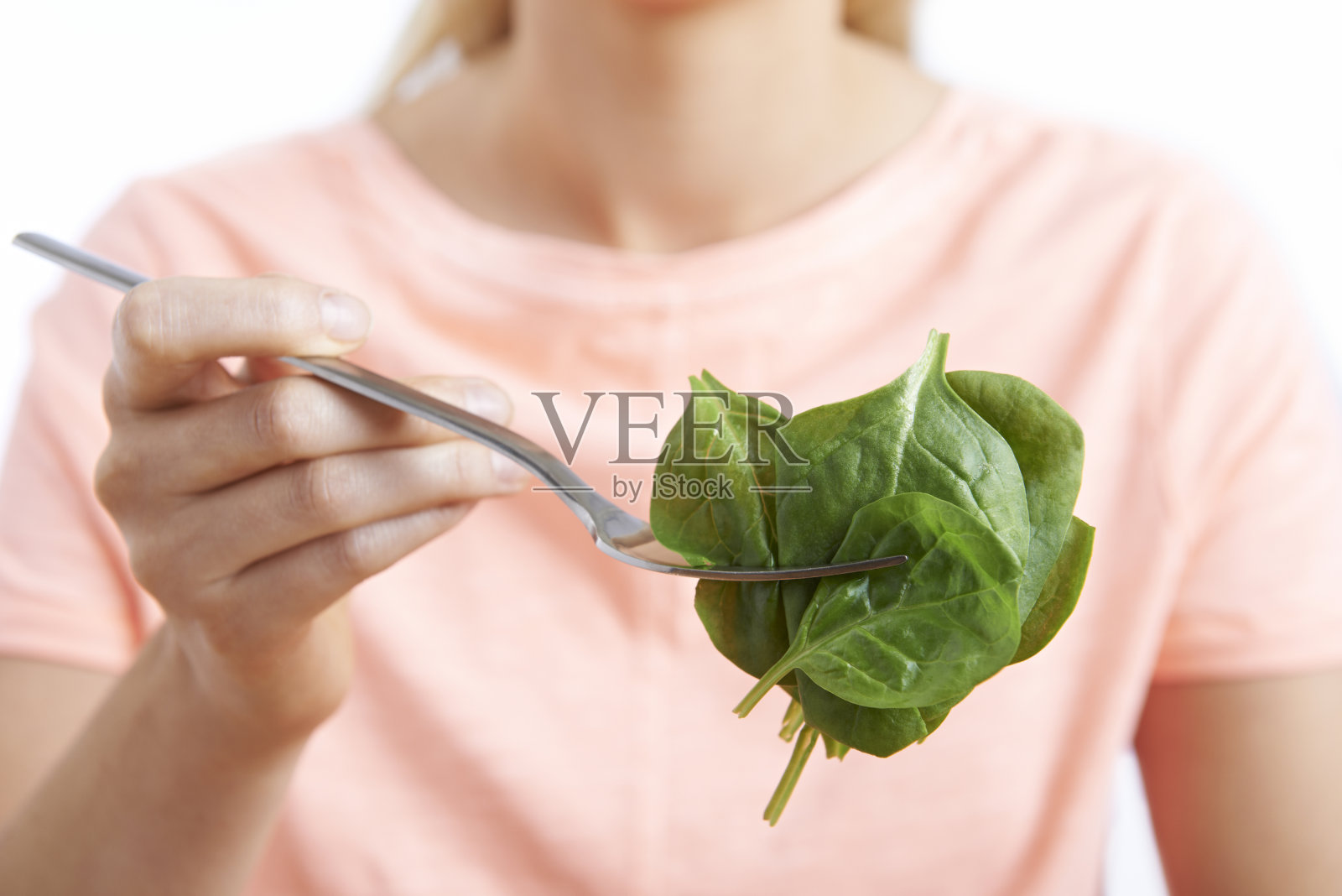 用叉子吃菠菜的女人的特写照片摄影图片